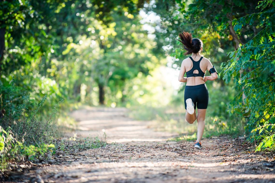 Young fitness woman running on a rural road. Sport woman running