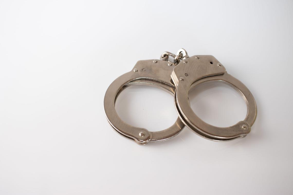 High angle shot of metal handcuffs isolated on a white background