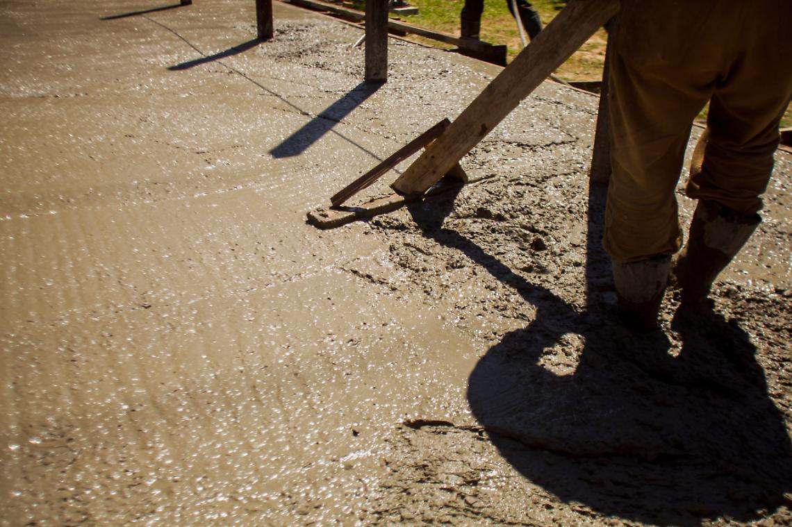 Close up of industrial worker smoothes cement or concrete