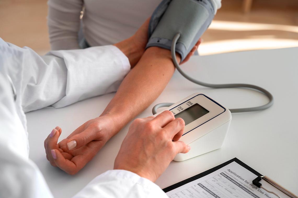 medico-ad-alto-angolo-che-utilizza-il-tensiometro